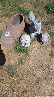 All four items arranged outdoors on dry grass: terracotta shoe planter, two concrete mouse heads, and squirrel statue.