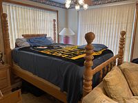 Bed frame with bedding and Steelers throw visible in room setting