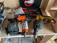 Overview of lot showing Pierce hydraulic device, DeWalt drill, white gloves, and assorted tools laid on shelf