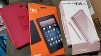 Amazon Fire 7 tablet box, red protective cover, Nintendo DS Lite pink boxed handheld