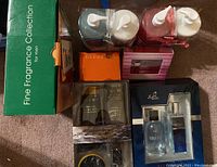 Photo showing assorted boxes of perfumes and two bottles of hand wash and lotion set wrapped with ribbons. Includes green Fine Fragrance Collection box, orange Gucci box, and other packaged items.
