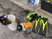 Overview of all items including two pairs of flippers, neoprene boots, gloves, snorkel, landing net, mesh bag, and a bucket.