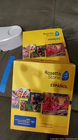 Photo of Rosetta Stone French and Spanish language software boxed sets with cultural images on yellow packaging.