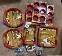 Full view of all red silicone baking pans and champagne sealers in packaging.