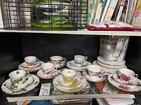 Photo showing five porcelain teacup sets with floral patterns and plates