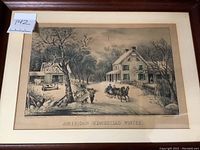 Framed etching of winter farmhouse scene labeled 'Annesdorn Homestead Winter' in a brown frame with matting.