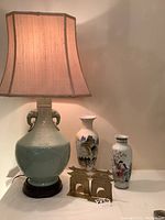 Full view of celadon lamp, two porcelain vases, and brass pagoda bookends showing size relation and details.
