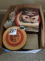 Top view of box showing two decorative tin containers, plastic bags with beads, and an instruction book on bead stringing.
