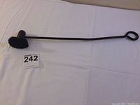 Full view of cast iron branding iron showing long handle and branding head
