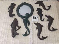 Full set of decorative cast iron hooks including mermaid, merman, seahorse, three dolphins and the small framed mirror.