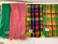 Four mohair scarves laid out side-by-side showing color and pattern: green, pink solid colors, and two plaid patterns.