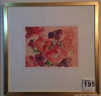 Frontal photo of framed watercolor painting showing red flowers against a red background, signed bottom left.