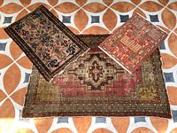 Three handmade rugs showing overall size variation and placement on tiled floor.