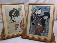 Two framed Japanese woodblock prints by Kitagawa Utamaro, displayed side by side with wooden frames