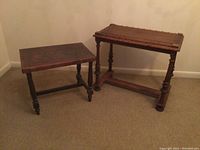 Pair of occasional tables, smaller with stamped leather top and larger wood table with decorative carved edges.