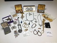 Overview photo showing the assortment of vintage crystal and glass beaded jewelry including earrings, bracelets, necklaces, brooches, buttons, and belt clasp in various colors and metal tones.