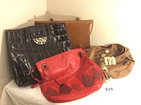 Four vintage leather bags displayed together: a dark brown pigskin briefcase with metal clasp, a black textured leather bag, a tan leather bag with sherpa trim, and a large red leather purse with diamond-pattern patches.