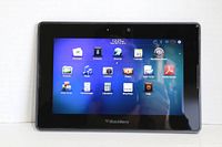 Front-facing image of the BlackBerry PlayBook tablet powered on showing home screen with multiple app icons.