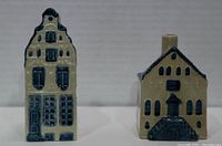 Front view of two KLM ceramic Delft Blue houses showing detailed windows, doors, and blue glaze.