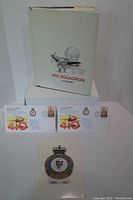 Image showing the 410 Squadron history book with white dust jacket and the pamphlet with squadron insignia along with two first day covers laid out in front.