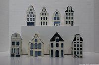 Front view of eight white and blue ceramic KLM houses arranged in two rows against a white background.
