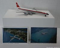 Red and white Aero-Mini Air Canada DC-8 metal model airplane with two landscape postcards placed in front
