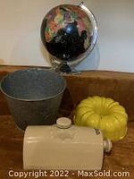 Lot with globe, galvanized pail, yellow bundt cake mold and beige ceramic foot warmer