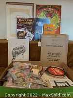 Photo showing a box with assorted vintage greeting cards, postcards, Disney items, Heddon catalog, Pelham Puppet play book, and magazines.