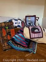 Grouped view of multiple quilted items including drawstring bag, small blanket, and wall hangings