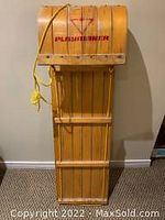 Front angled view of wooden toboggan showing 'Play Maker' branding and yellow rope attached