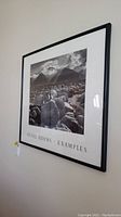 Angled side view of framed Ansel Adams print hanging on wall showing the print, frame, and text below image.