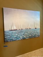 Full view of canvas art showing a seascape with multiple sailboats on water, wall mounted.