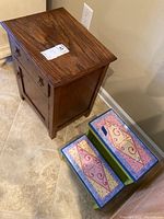 View of wooden end table against wall, showing finish and hardware details