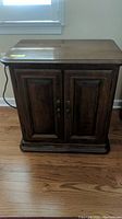 Front view of the Ethan Allen nightstand showing dark wood finish and double doors with metal handles.