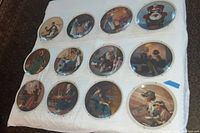 Twelve circular Mother's Day collectible plates by Rockwell Society of America displayed on a white cloth, showing various sentimental Norman Rockwell artwork and metal hangers visible around plate edges.
