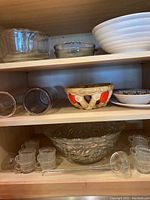 Shelving unit holding punch bowl set, assorted bowls and glass cups