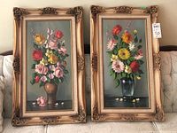 Pair of framed floral oil paintings by V. Beke, showing full artworks and frames.