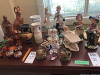Wide shot showing all items in the lot including Mum ceramic figurines, ESD lustreware, and carved wood figures