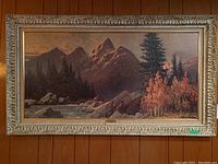 Full view of the framed print showing the mountainous landscape and detailed ornate frame