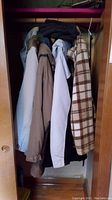 Four jackets hanging in a closet, showing variety of colors and patterns including a beige jacket and a plaid jacket