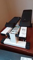 Full view of the Healthware exercise pedal machine showing dual black pedals on white frame with label attached