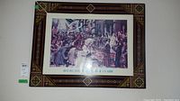 Full view of framed print with carved frame showing decorative tile pattern and historical scene.