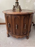 Front and side views of the first round wooden side table with carved door panels and brass handles, showing the diamond lattice pattern and carved feet.