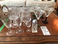 Wide shot showing all stemware items and salt shaker arranged on a wooden table near a sofa