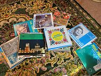 Assorted Ukrainian LP albums with colorful covers laid out on patterned carpet, showing various titles and images including traditional Ukrainian scenes and musicians.