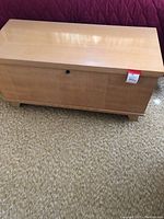Front view of cedar chest showing light wood finish and lock on front panel.