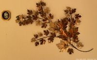 Large metal autumn leaf wall art with detailed gold, bronze, and copper colored leaves arranged on wall