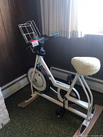 Schwinn exercise bike positioned near window, shows side profile and seat details.