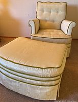 Ivory upholstered chair and ottoman set with green velvet trim shown in room setting.
