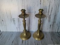 Pair of two vintage brass candlesticks with round bases and fluted stems, showing original patina and excellent condition.